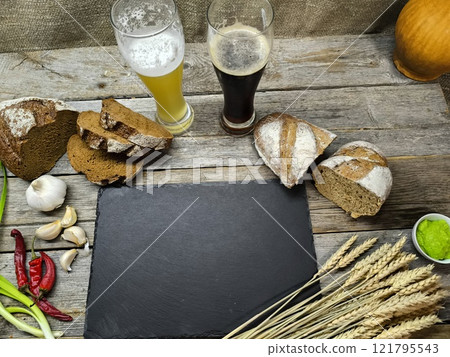 slices of bread and glasses of beer are located near the sliced granite board 121795543