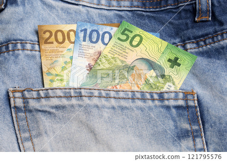 Swiss franc in the pocket of blue jeans Swiss franc in the pocket of blue jeans 121795576