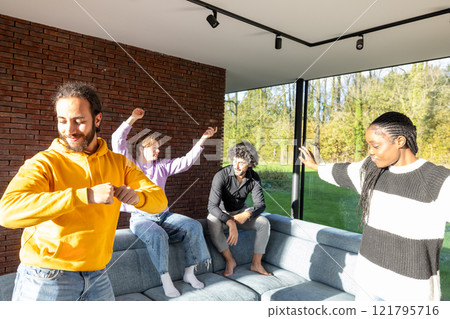 A group of friends is enjoying a sunny day indoors, dancing and having fun together A group of friends is enjoying a sunny day indoors, dancing and having fun together 121795716