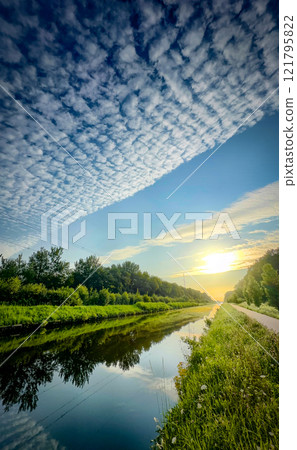 A Serene River Landscape at Sunset Featuring Striking Clouds in a Peaceful Atmosphere A Serene River Landscape at Sunset Featuring Striking Clouds in a Peaceful Atmosphere 121795822