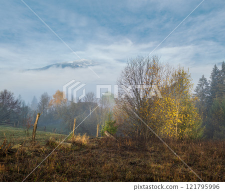 Cloudy and foggy morning late autumn mountains scene. Peaceful picturesque traveling, seasonal, nature and countryside beauty concept scene. Carpathian Mountains, Ukraine. Cloudy and foggy morning late autumn mountains scene. Peaceful picturesque traveling, seasonal, nature and countryside beauty concept scene. Carpathian Mountains, Ukraine. 121795996