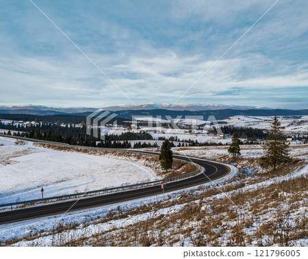 Asphalt road curve and winter beginning in Mountains, Ukraine, Carpathian. 121796005