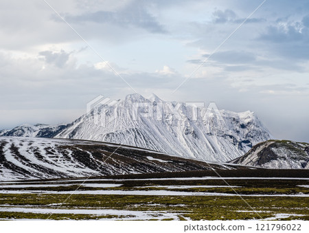 Colorful Landmannalaugar mountains under snow cover in autumn, Iceland. Lava fields of volcanic sand in the foreground. Colorful Landmannalaugar mountains under snow cover in autumn, Iceland. Lava fields of volcanic sand in the foreground. 121796022