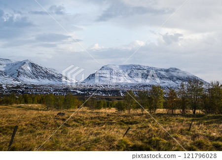 Beautiful mountain view during auto trip in North Iceland. Spectacular Icelandic landscape with  scenic nature: mountains, fields, clouds, glaciers, rocks, groves. 121796028