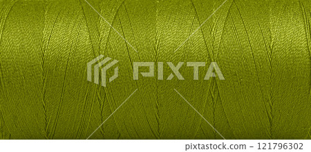 Texture of threads in a spool of green color on a white background Texture of threads in a spool of green color on a white background 121796302