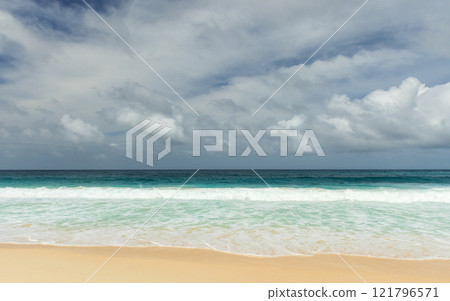 Shore waves and white sand are under dramatic dark cloudy sky Shore waves and white sand are under dramatic dark cloudy sky 121796571