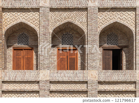 Madrasah wall with decorated arched balconies. Bukhara, Uzbekistan 121796617