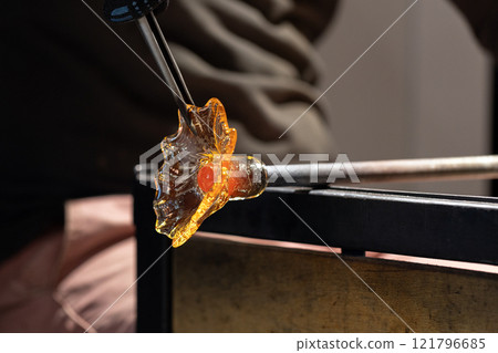 Molding molten glass into a flower shape Molding molten glass into a flower shape 121796685