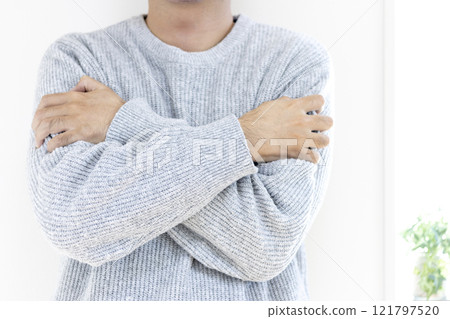 A man in his 30s (Japanese, no face) feeling cold and wearing a sweater 121797520