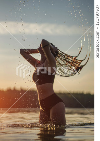 young carefree woman swimming in sea and relax at beach, splashing water with hair and have fun, vacations concept 121797937