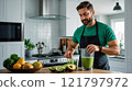 A man mixing a green smoothie in a modern kitchen with avocados, kiwis, and lemons on the countertop, ready for a healthy drink. 121797972