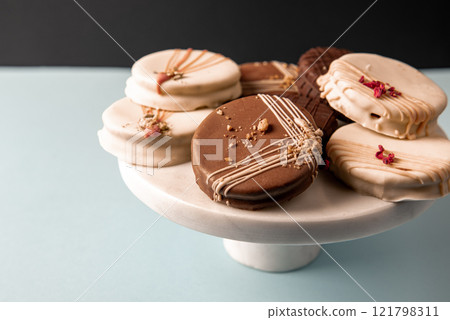 Delicious Ischler cookies with brown an white chocolate glaze on dessert stand. Delicious Ischler cookies with brown an white chocolate glaze on dessert stand. 121798311