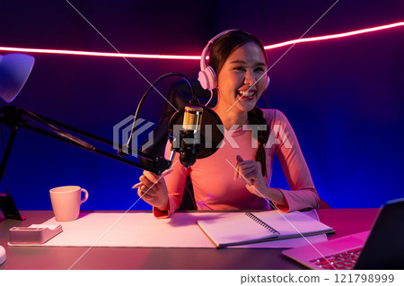 Smiling creative young beautiful Asian influencer talking in channel. Stratagem. 121798999