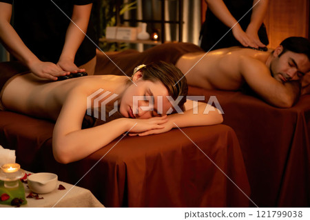 Hot stone massage at spa salon in luxury resort with warm candle light.Quiescent Hot stone massage at spa salon in luxury resort with warm candle light.Quiescent 121799038