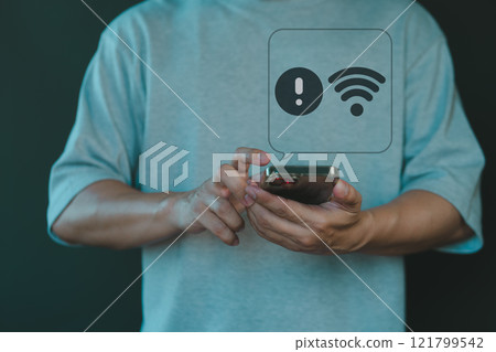 A person interacts with a smartphone, displaying a warning notification symbolizing a Wi-Fi connection issue. The hand gestures emphasize the frustration of poor or lost internet connectivity. 121799542