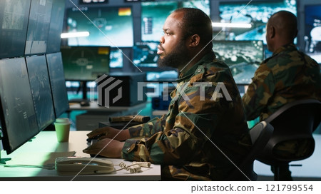 Intelligence corps expert in military HQ base gathering information on enemy troops. Officer arriving at work in base of operations, starting assessment of enemy vulnerabilities, tracking, camera A 121799554