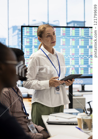 General manager and investors gathering for an investment fair meeting, discussing potential growth opportunities. Business staff reviewing financial projections and strategic initiatives. 121799699