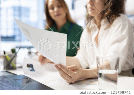 HR colleagues doing screening, looking at CV files to determine if candidates posses skills and experience needed to fulfil the role. Recruiters browsing resumes, evaluating applicants 121799741
