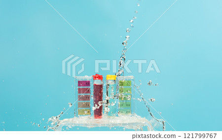 PH acid level test kit on quality water on purple yellow. Water splashing on PH acid level tester kit over blue background 121799767