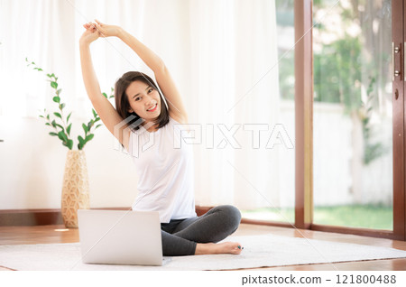 woman stretching  in living room at her house 121800488
