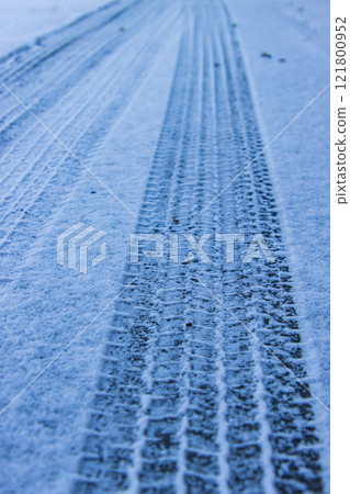 Tire marks left on the snowy road Tire marks left on the snowy road 121800952