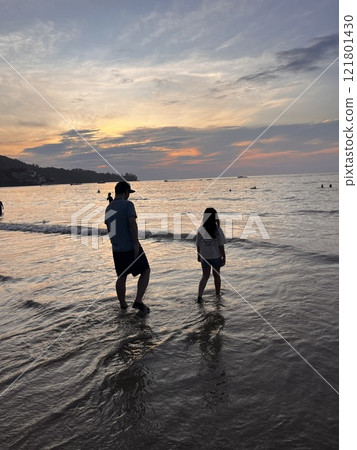 Parents and children watching the sunset 121801430