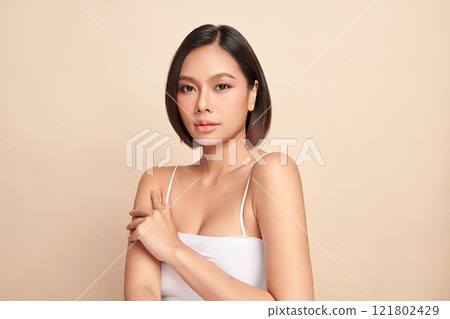 Beautiful young asian woman with clean fresh skin on beige background, Face care, Facial treatment, Cosmetology, beauty and spa, Asian women portrait. Beautiful young asian woman with clean fresh skin on beige background, Face care, Facial treatment, Cosmetology, beauty and spa, Asian women portrait. 121802429