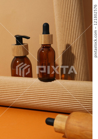 Cosmetic oil in a brown bottle with a wooden cap 121802576