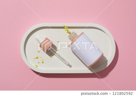 Cosmetic oil in a bottle on a pink background Cosmetic oil in a bottle on a pink background 121802592