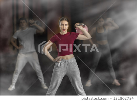 Woman exercising with a kettlebell 121802784