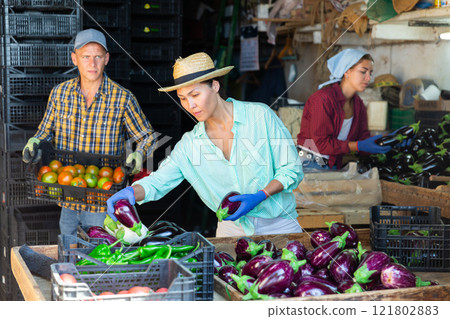 Two women and one man working in warehouse 121802883