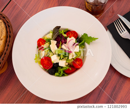 Salad with lettuce, tomatoes, onion, olives and cheese 121802993