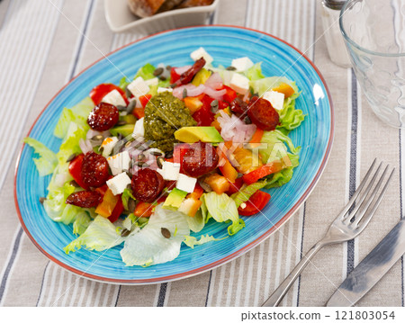 Feta and chorizo salad with avocado and pesto sauce 121803054