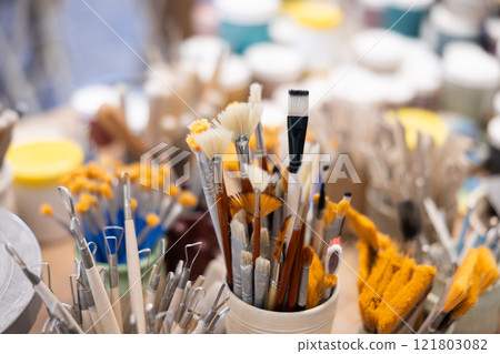 Variety of brushes, wooden spatulas, scrapers used in manual production of ceramic products. Variety of brushes, wooden spatulas, scrapers used in manual production of ceramic products. 121803082