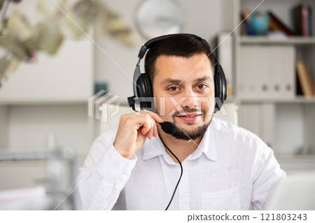 Portrait of positive man office worker wearing headset Portrait of positive man office worker wearing headset 121803243