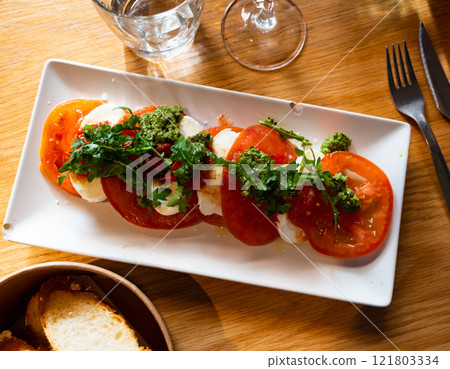 Caprese salad served with arugula 121803334