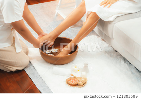 Woman indulges in blissful foot massage at luxurious spa salon. Quiescent Woman indulges in blissful foot massage at luxurious spa salon. Quiescent 121803599