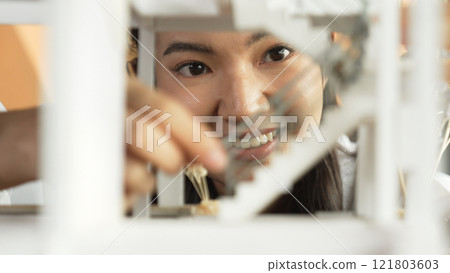 Closeup portrait of skilled asian architect reviewing house model. Manipulator. Closeup portrait of skilled asian architect reviewing house model. Manipulator. 121803603