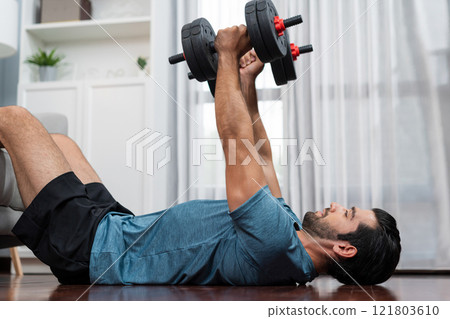Athletic body and active sporty man lifting dumbbell at gaiety home exercise. 121803610