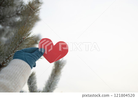 A Heartfelt Winter Gesture Featuring a Red Heart Set Against a Beautiful Snowy Background 121804520