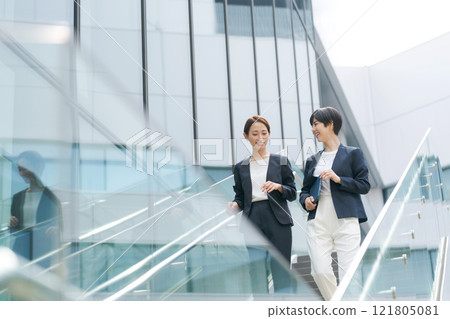 Businesswoman walking down the stairs in the office Businesswoman walking down the stairs in the office 121805081