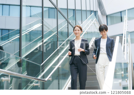 Businesswoman walking down the stairs in the office Businesswoman walking down the stairs in the office 121805088