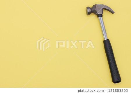 Hammer on a yellow background 121805203
