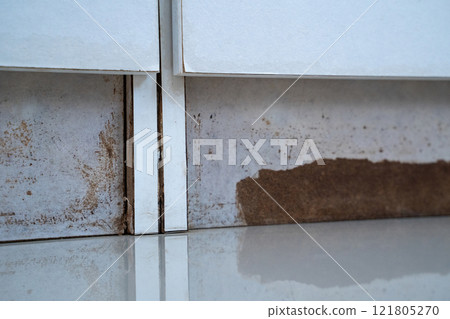 the closet with a white cabinet and a brown stain on the floor 121805270