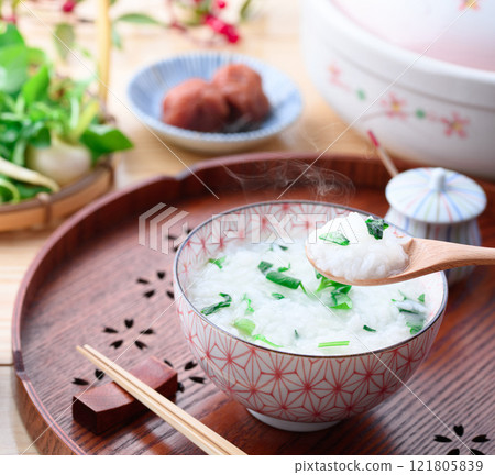 Eating Nanakusa-gayu (rice porridge with seven herbs) to pray for good health 121805839