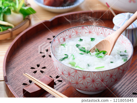 Eating Nanakusa-gayu (rice porridge with seven herbs) to pray for good health 121805845