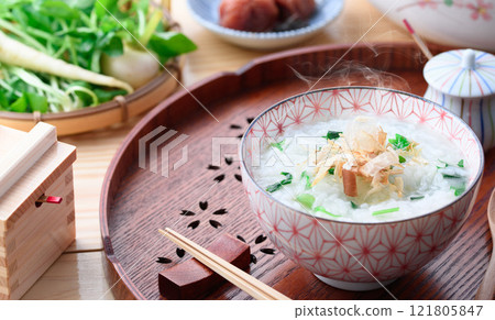 Eating Nanakusa-gayu (rice porridge with seven herbs) to pray for good health Eating Nanakusa-gayu (rice porridge with seven herbs) to pray for good health 121805847