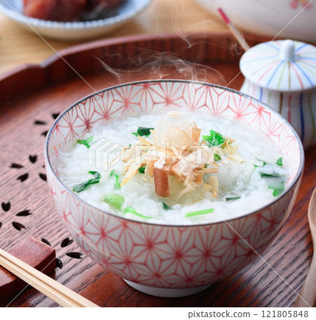 Eating Nanakusa-gayu (rice porridge with seven herbs) to pray for good health Eating Nanakusa-gayu (rice porridge with seven herbs) to pray for good health 121805848