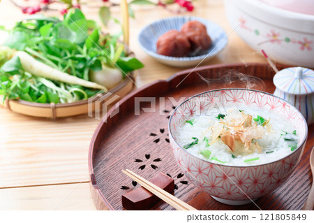 Eating Nanakusa-gayu (rice porridge with seven herbs) to pray for good health Eating Nanakusa-gayu (rice porridge with seven herbs) to pray for good health 121805849