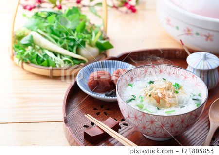 Eating Nanakusa-gayu (rice porridge with seven herbs) to pray for good health 121805853